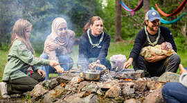 Speidere som griller pinnebrød over bål. Speidere som griller pinnebrød over bål.