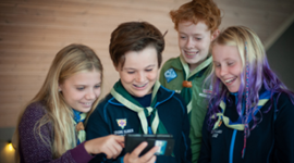 Fire speidere som ser på samme mobiltelefon.