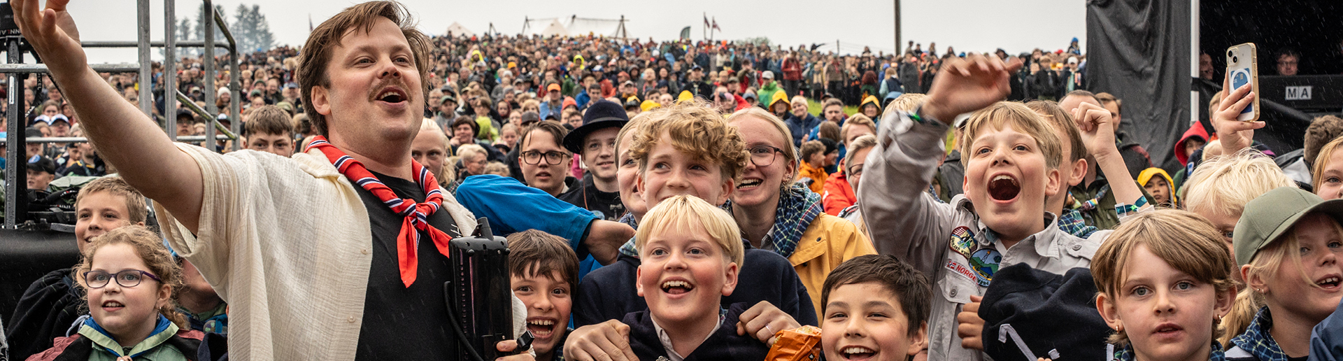 Speidere som jubler og smiler på leirbål. 