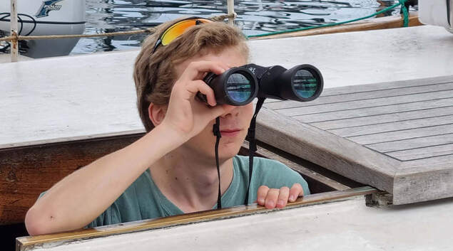 En speiderleder ser i kikkert. En speiderleder ser i kikkert.