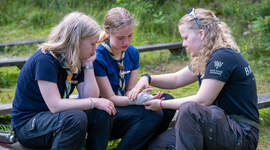 Speiderleder sammen med speidere i instruksjonssituasjon.