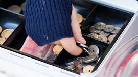 Penger i et pengeskrin.
